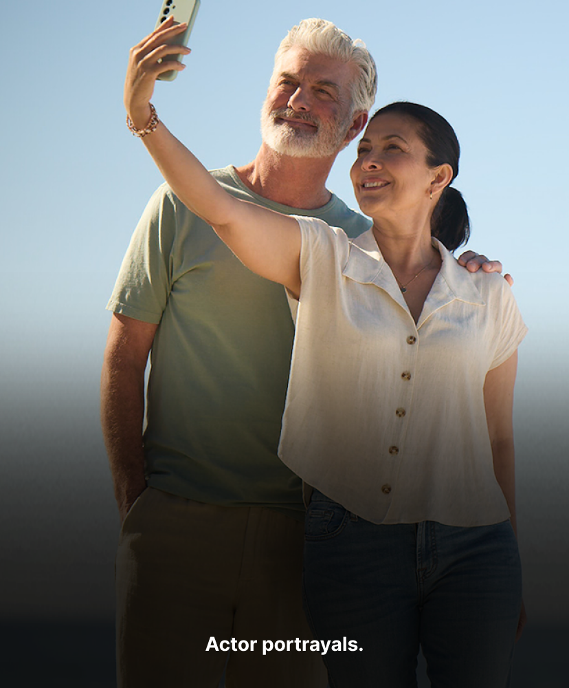 Two people at beach taking selfie. Actor portrayals.